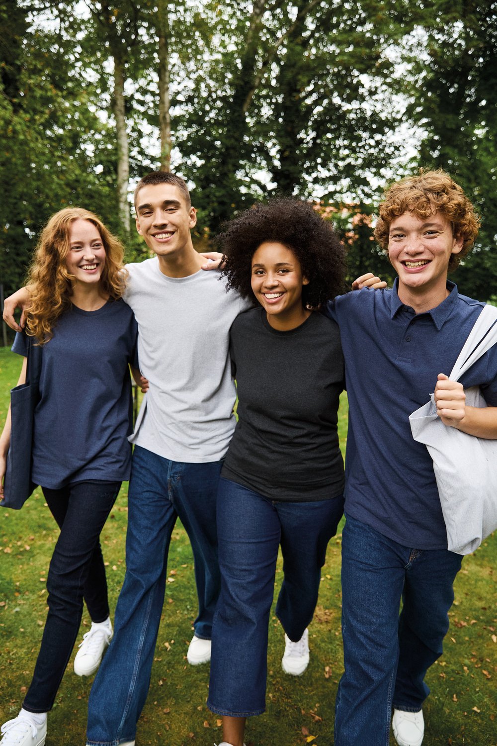 Vier junge Erwachsene in PROLINQ Team Capsule 2026 · Polos, T-Shirts, Tote-Bags